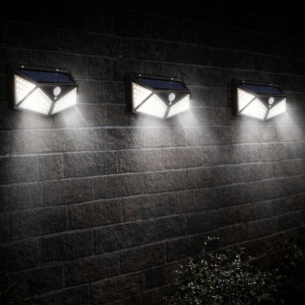 faretto da parete con pannello solare 20w - foto 3 Quattro faretti da parete con pannello solare montati su muro di mattoni, accesi di notte in sequenza