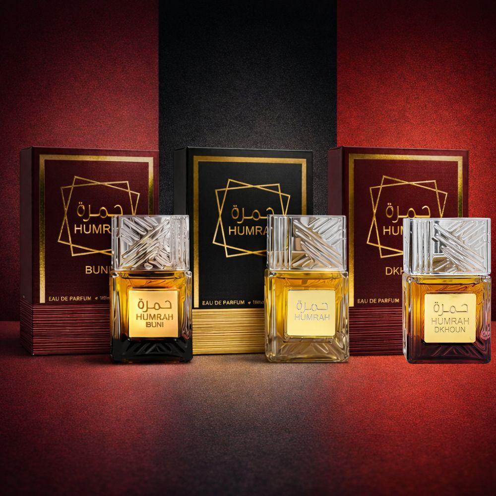 humrah eau de parfum 100 ml profumo orientale - foto 4 Tre flaconi Humrah Eau De Parfum in varianti diverse con scatole coordinate su sfondo rosso e nero